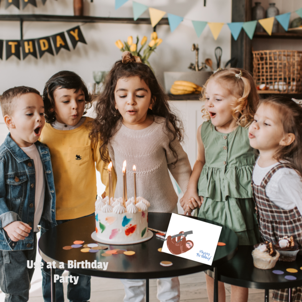group of kids around a table one blowing out the candles with use at birthday parties and a sloth landscape image sitting on the table