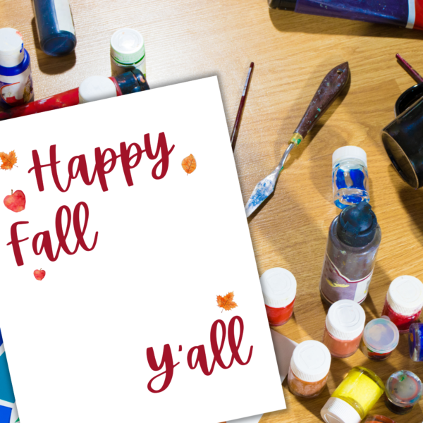 Desk with paints and a close up of happy fall y'all sheet