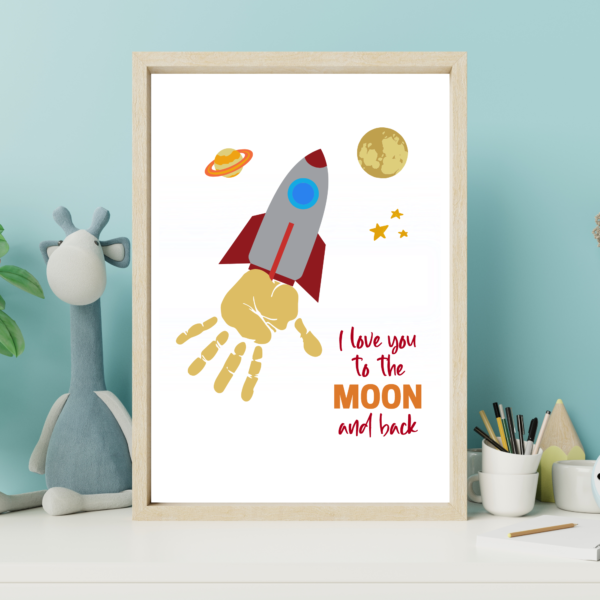 teal background with finished Love you to the moon and back rocketship in a picture frame.