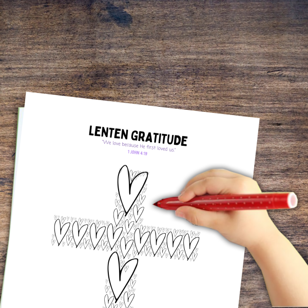 wood table background with little kids hand holding marker doing the lenten gratitude for little kids page of the worksheets