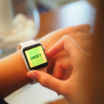 smartwatch on wrist with yellow background with LUCKY in green