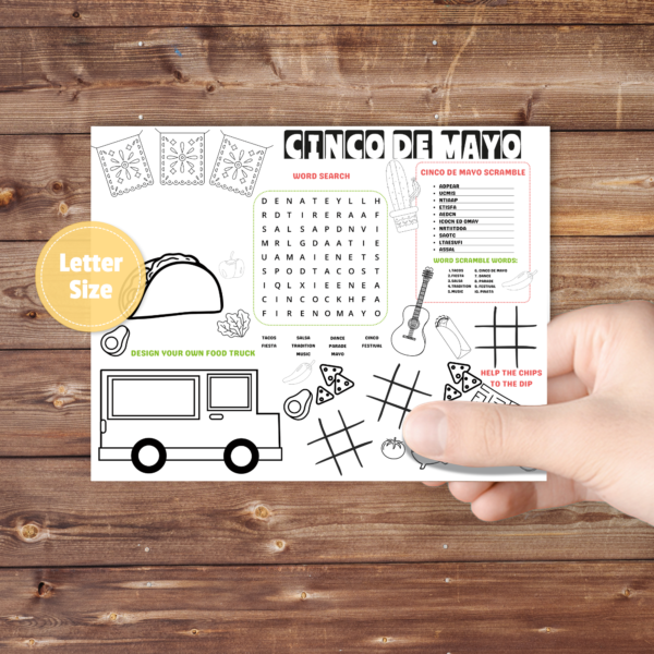 Brown table with hand holding the taco activity placemat showing taco, taco truck, maze, coloring, designing a food truck, word search and scramble, personalize above the taco. has a cactus, guitar, and chips too yellow bubble with LETTER SIZE
