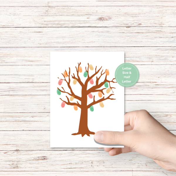 wood background, hand holding image of tree with fingerprints in orange, red, green, yellow, has green circle that says what a finished product looks like