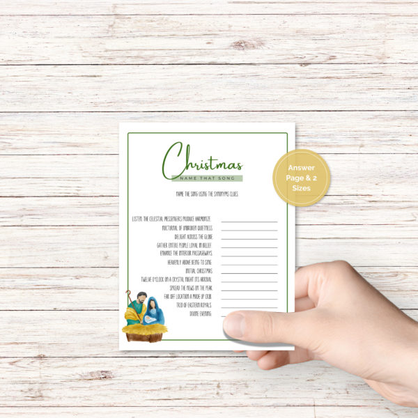 wood background, with a hand holding the christmas party game with nativity with green border, has a gold dot that says answer page and 2 sizes.