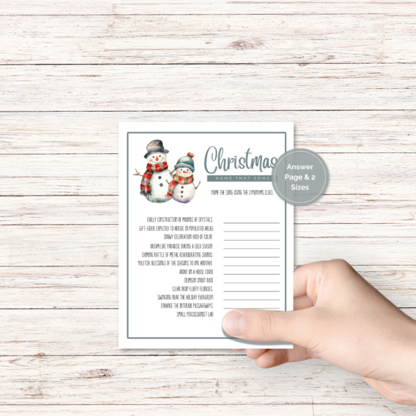 wood background, with a hand holding the winter party game with snowman with teal border, has a blue dot that says answer page and 2 sizes.