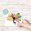 wood background, with hand holding paper with footprint in the middle of the turkey leaves or pretty bright colors to show what it looks like done. Teal circle with What a finished product looks like.