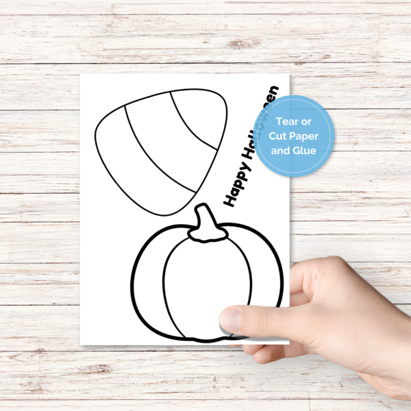 white wood background, hand holding paper that says Happy Halloween that have a pumpkin and candy corn on it. blue circle says tear or cut paper and glue.