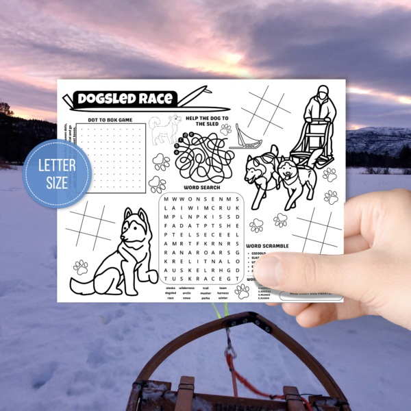 snowy background with part of a sled in the picture background, hand holding the place mat for dog sled racing, has blue circle that says letter size, shows games and activities for unit study fun