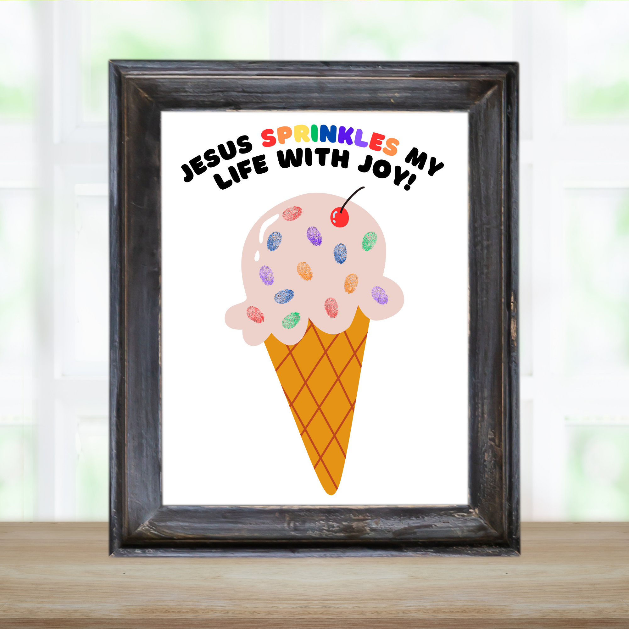 Black frame holding a finished Jesus sprinkles my life with joy craft with an ice cream cone with fingerprints as the sprinkles.